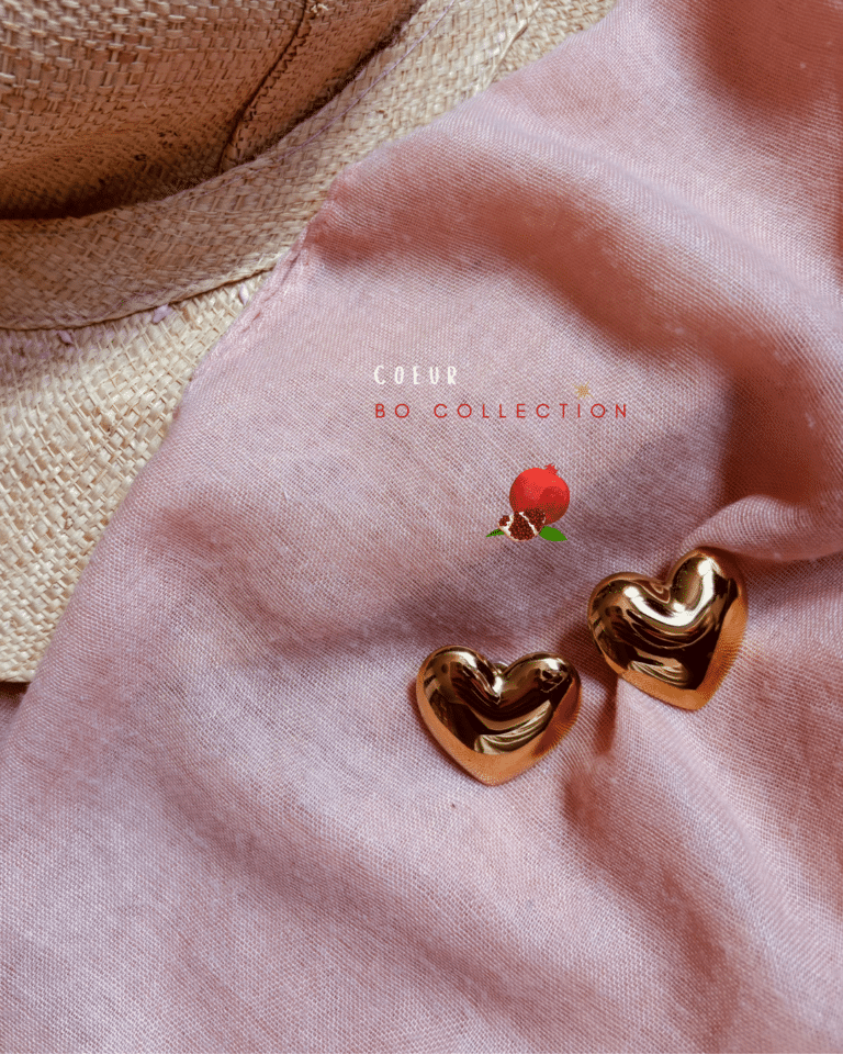 a pair of gold hearts on a pink cloth