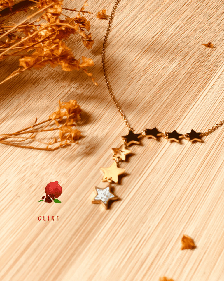 a gold star necklace on a wood surface